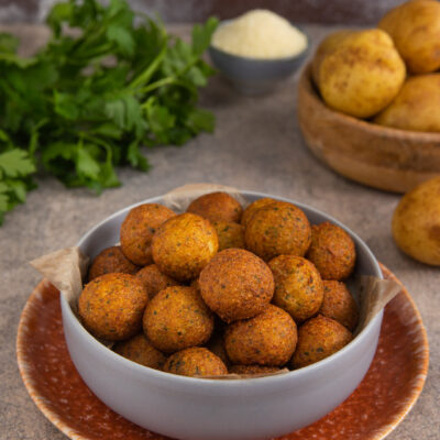 Palline croccanti di patate dorate e fritte impilate in una ciotola