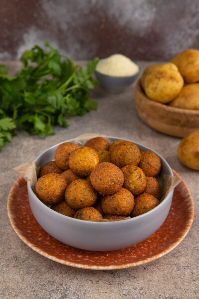 Palline croccanti di patate dorate e fritte impilate in una ciotola