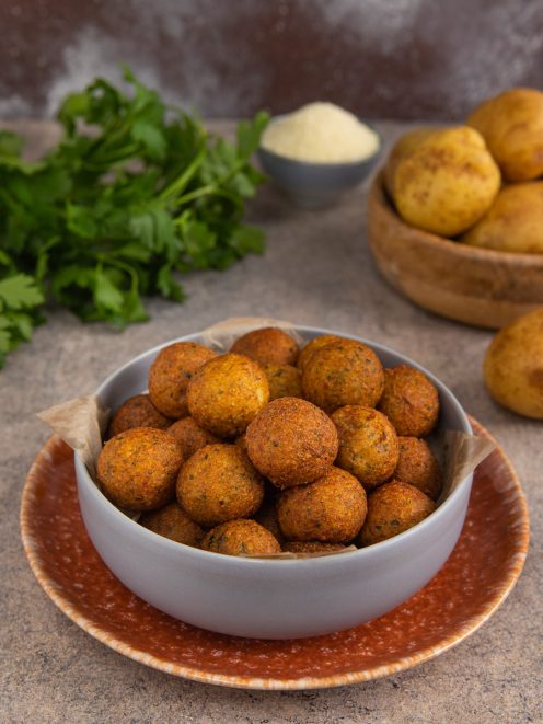 Palline croccanti di patate dorate e fritte impilate in una ciotola
