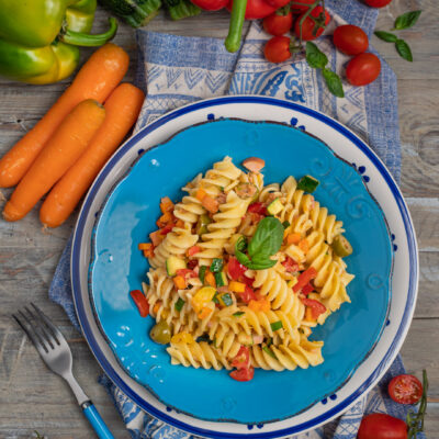 Pasta fredda con fusilli, verdure miste, pomodorini e foglie di basilico fresco