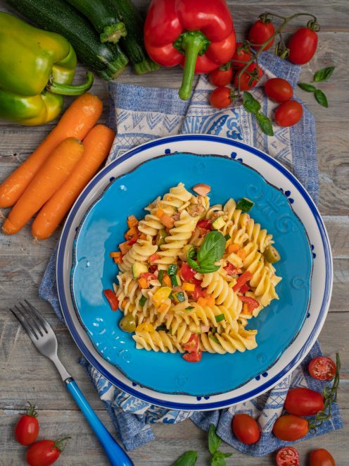Pasta fredda con fusilli, verdure miste, pomodorini e foglie di basilico fresco
