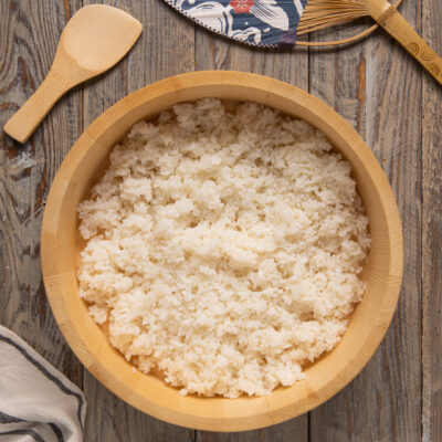 Riso per sushi condito e raffreddato in una ciotola di legno hangiri