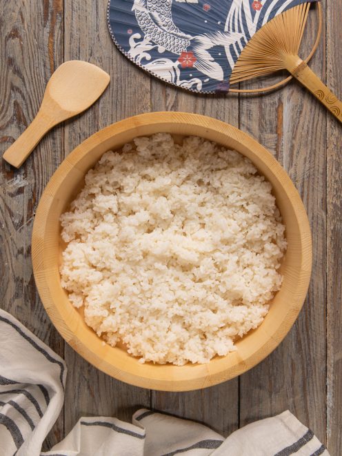 Riso per sushi condito e raffreddato in una ciotola di legno hangiri