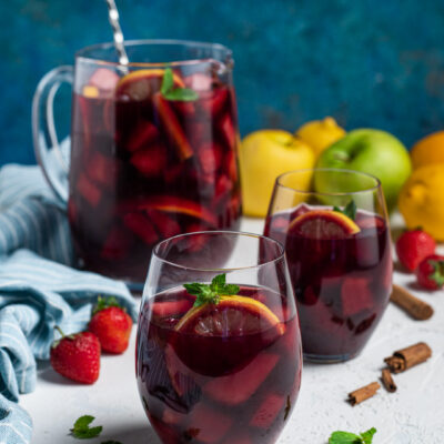 Sangria al vino rosso con frutta a pezzi, fettine d'arancia e foglie di menta fresca