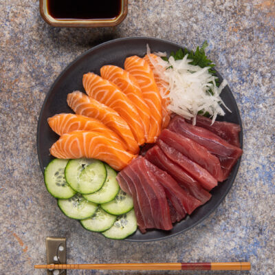Sashimi misto con fette di salmone e tonno, cetriolo a rondelle e daikon grattugiato