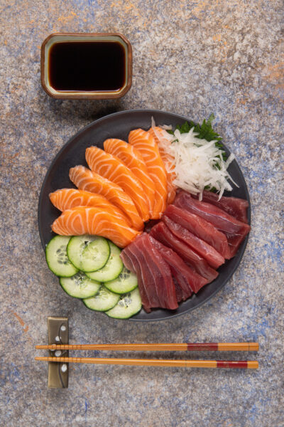 Sashimi misto con fette di salmone e tonno, cetriolo a rondelle e daikon grattugiato