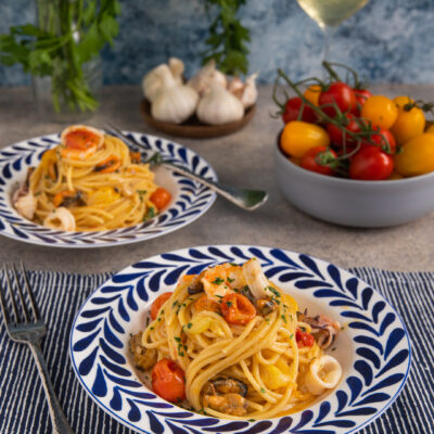 Spaghetti allo scoglio con cozze, calamari, gamberi e pomodorini, guarniti con prezzemolo tritato