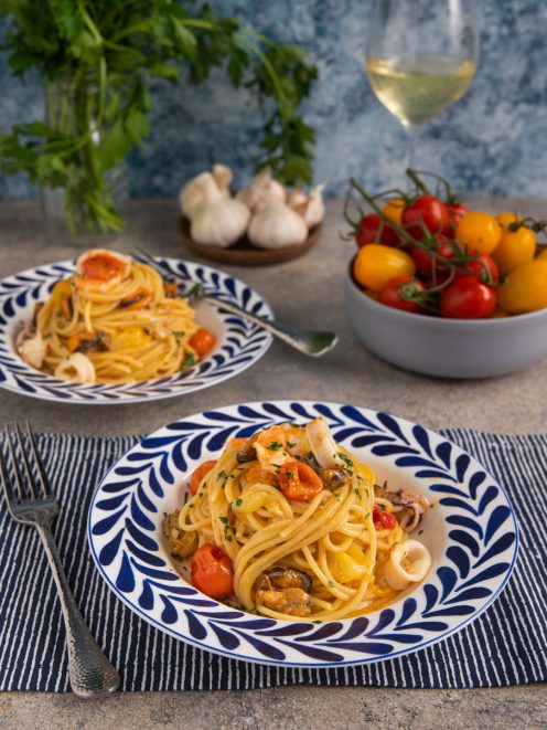 Spaghetti allo scoglio con cozze, calamari, gamberi e pomodorini, guarniti con prezzemolo tritato
