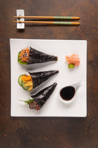 Tre temaki di nori con salmone, verdure e tonno serviti con salsa di soia e zenzero