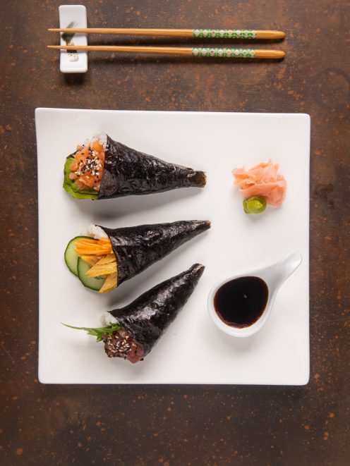 Tre temaki di nori con salmone, verdure e tonno serviti con salsa di soia e zenzero