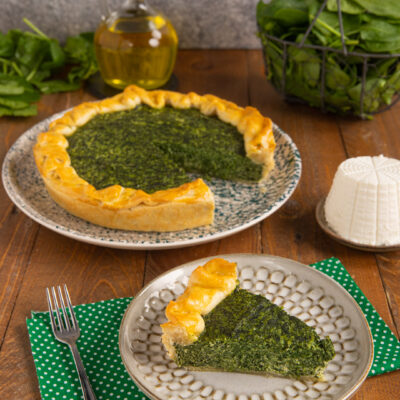 Torta salata ricotta e spinaci con una fetta servita separata, pasta dorata e ripieno verde