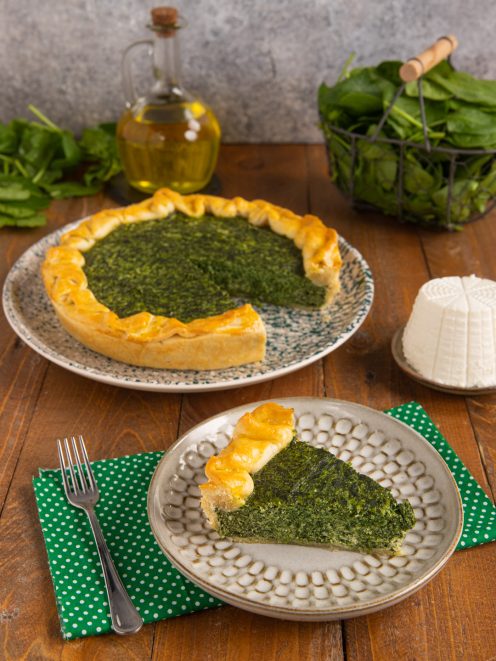 Torta salata ricotta e spinaci con una fetta servita separata, pasta dorata e ripieno verde