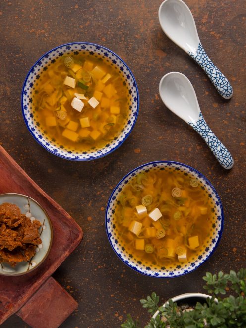 Zuppa di miso con cubetti di tofu e rondelle di cipollotto in brodo ambrato