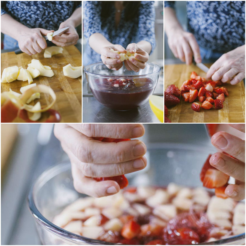 Mani che tagliano mela e fragole a tocchetti e le aggiungono al mix di liquori per la sangria