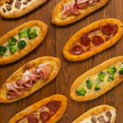 Barchette di pizza a canoa farcite con salsiccia, prosciutto crudo, broccoli e peperoni piccanti