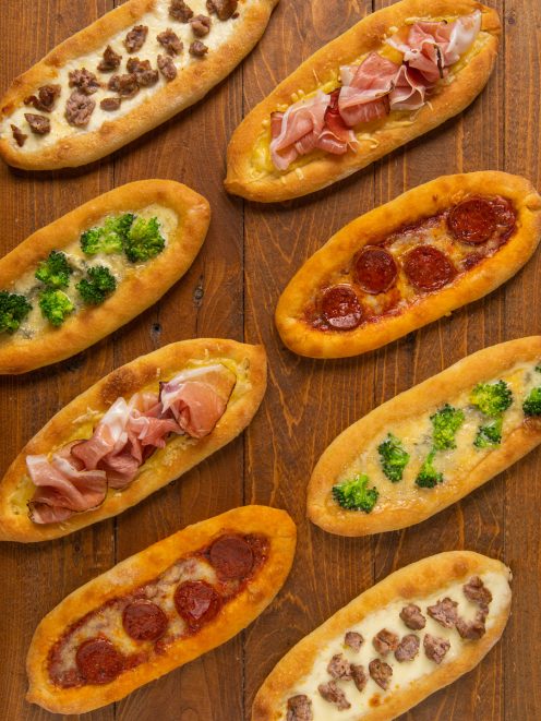 Barchette di pizza a canoa farcite con salsiccia, prosciutto crudo, broccoli e peperoni piccanti