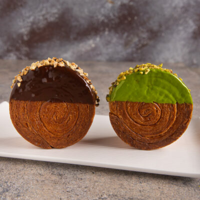 New York roll a spirale glassati al cioccolato e pistacchio con granella croccante in superficie