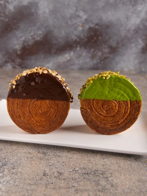 New York roll a spirale glassati al cioccolato e pistacchio con granella croccante in superficie