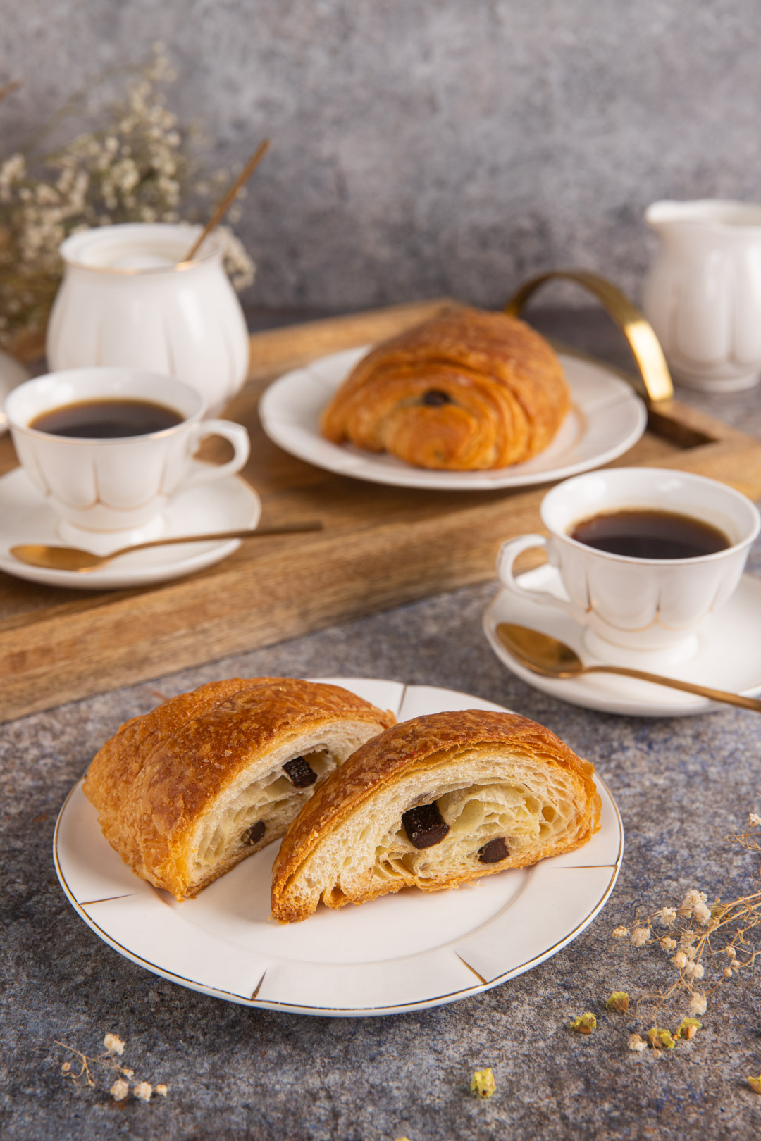 Pain au chocolat tagliato a metà con gocce di cioccolato visibili nella pasta sfogliata