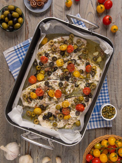 Pesce spada al forno con olive, pomodorini colorati, capperi e acciughe