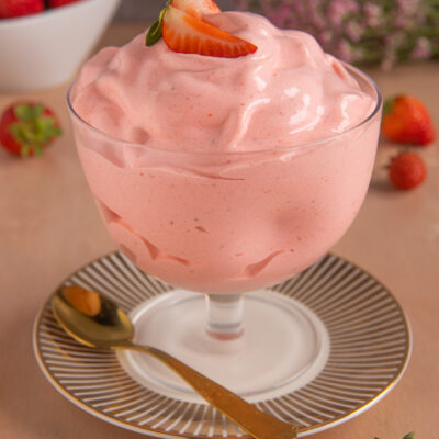 Spumone alle fragole soffice e spumoso, guarnito con una fetta di fragola fresca