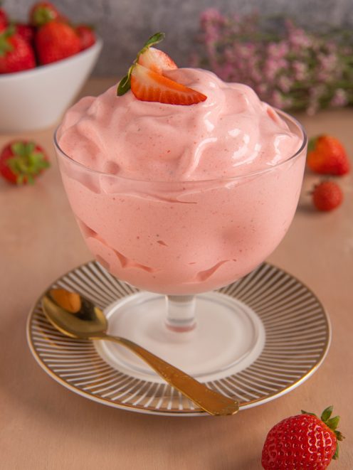 Spumone alle fragole soffice e spumoso, guarnito con una fetta di fragola fresca