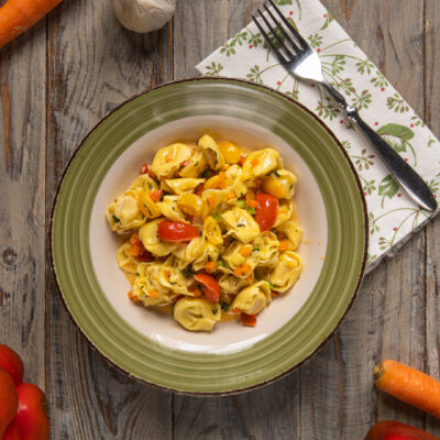 Tortellini al crudo con verdure alle erbe e stracchino, con pomodorini e carote a dadini
