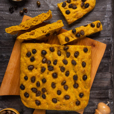 Focaccia gold alla curcuma tagliata a fette, farcita di olive nere e con mollica alveolata