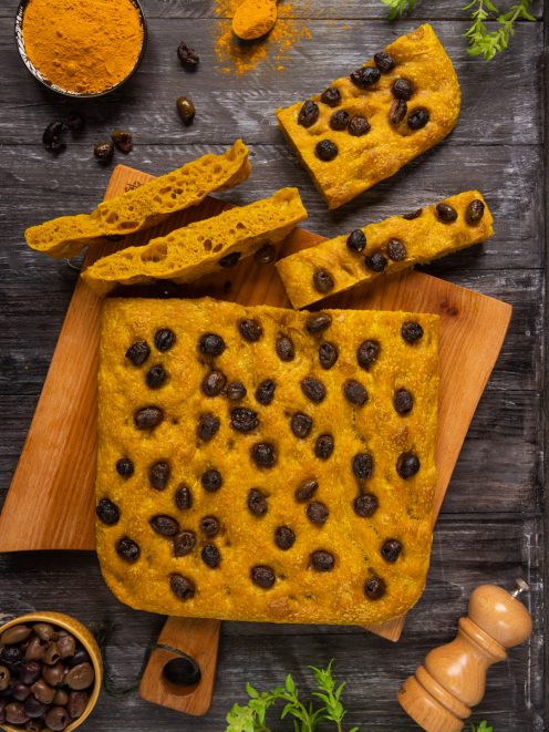 Focaccia gold alla curcuma tagliata a fette, farcita di olive nere e con mollica alveolata