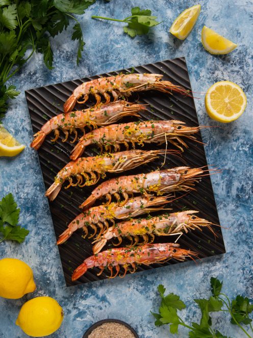 Gamberoni al forno con scorza di limone e prezzemolo tritato