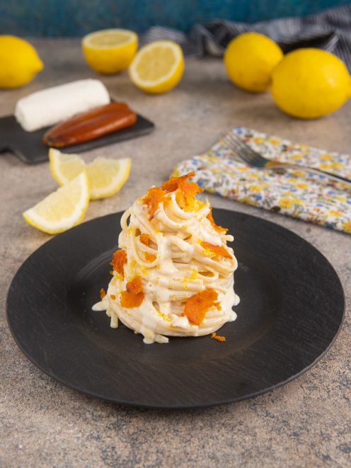 Linguine al caprino con limone e bottarga cremose, guarnite con scorza grattugiata e scaglie croccanti