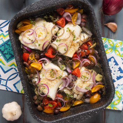 Merluzzo al forno con pomodorini colorati, olive, cipolla rossa e timo fresco