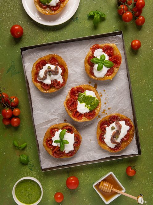 Mini tatin ai pomodorini con burrata, guarnite a scelta con pesto, basilico o acciughe e capperi
