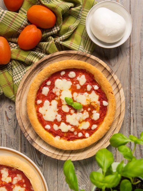 Pizza senza glutine con salsa di pomodoro, mozzarella sciolta e foglie di basilico fresco