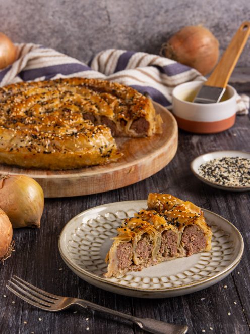 Burek con ripieno di carne macinata avvolto in pasta sfoglia croccante, cosparso di semi di sesamo