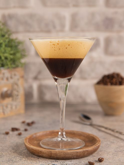 Caffè shakerato servito in coppa martini con schiuma dorata in superficie