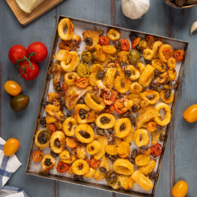 Calamari al forno in teglia con pomodorini, olive e capperi croccanti