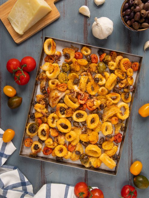 Calamari al forno in teglia con pomodorini, olive e capperi croccanti