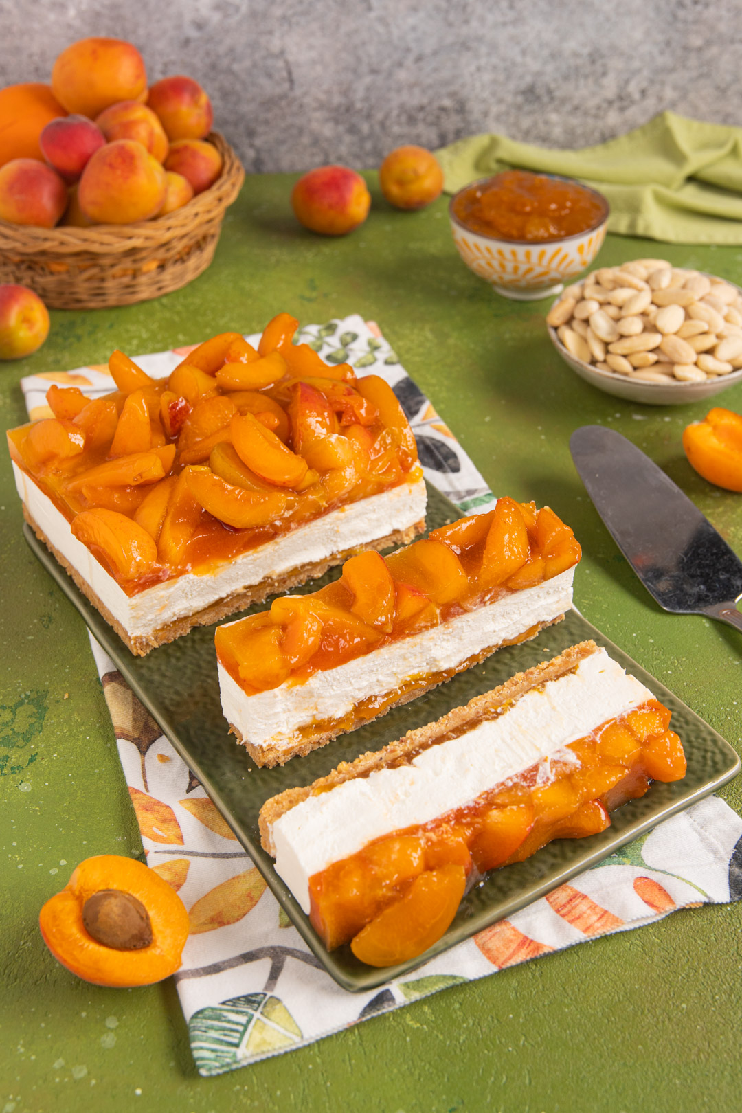Cheesecake alle albicocche decorata con spicchi di frutta e coulis lucida in superficie