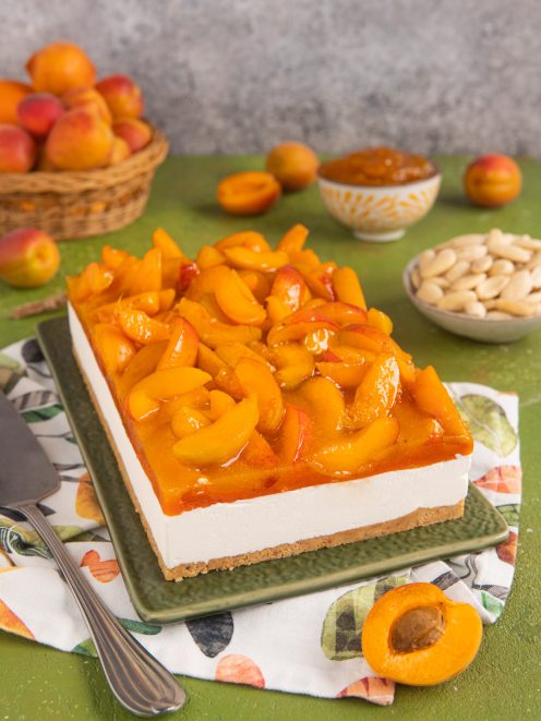Cheesecake alle albicocche con base di biscotto, crema bianca e spicchi di albicocche caramellate in superficie