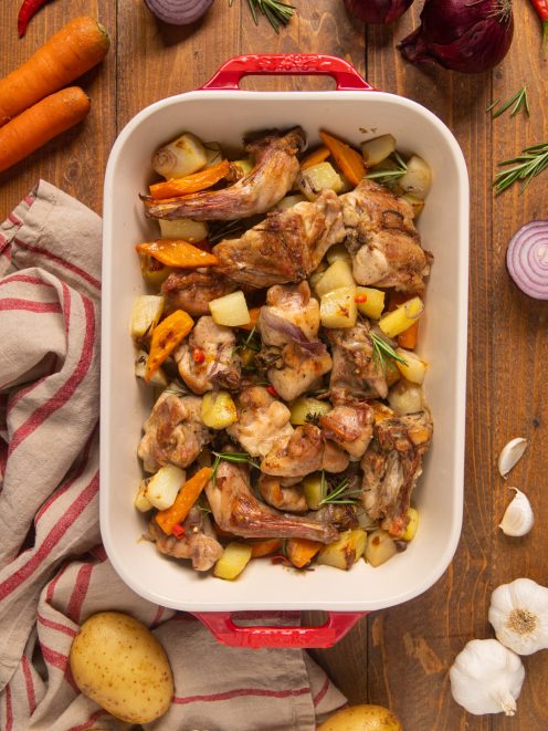Coniglio al forno con patate a cubetti, carote e rametti di rosmarino