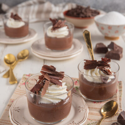 Dessert al cioccolato in coppette con ciuffo di panna montata e scaglie di cioccolato fondente