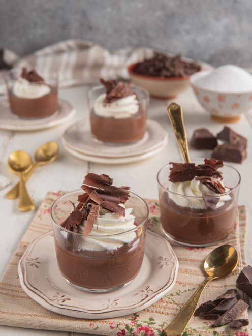 Dessert al cioccolato in coppette con ciuffo di panna montata e scaglie di cioccolato fondente