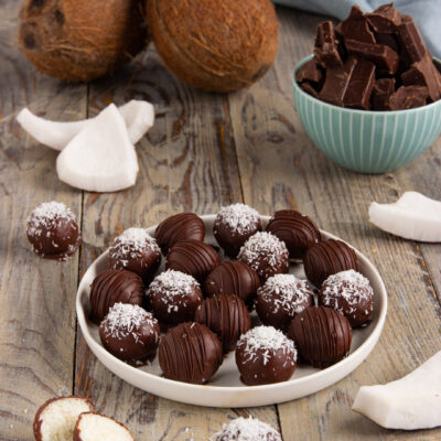 Dolcetti al cocco e cioccolato fondente con scaglie di cocco, uno spaccato mostra il ripieno bianco