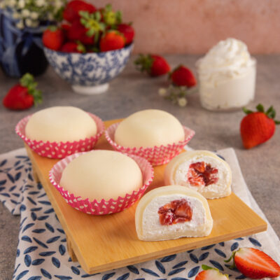 Mochi alla fragola tagliati a meta con ripieno di crema e fragole a pezzetti