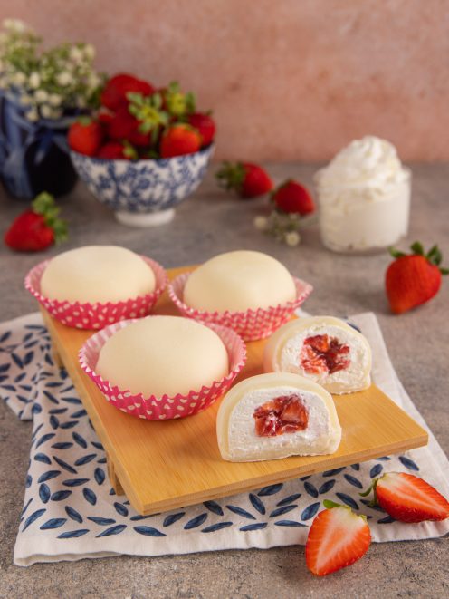 Mochi alla fragola tagliati a meta con ripieno di crema e fragole a pezzetti