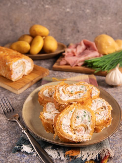 Rotolo di patate croccante affettato, con ripieno cremoso di prosciutto ed erbe