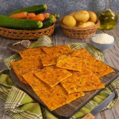 Schiacciata di verdure tagliata a pezzi, dorata e croccante, con zucchine e carote visibili nell'impasto