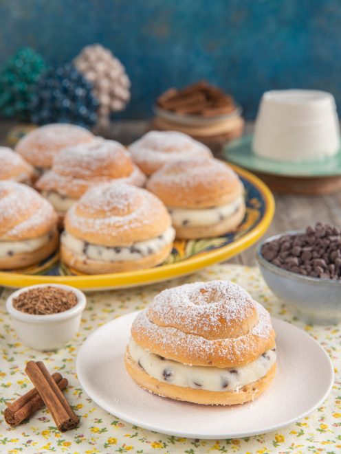 Biscotti di San Martino farciti con crema alla ricotta e gocce di cioccolato, spolverati di zucchero a velo