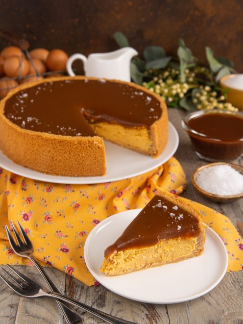 Cheesecake al caramello salato con glassa lucida e fiocchi di sale in superficie, fetta pronta da servire
